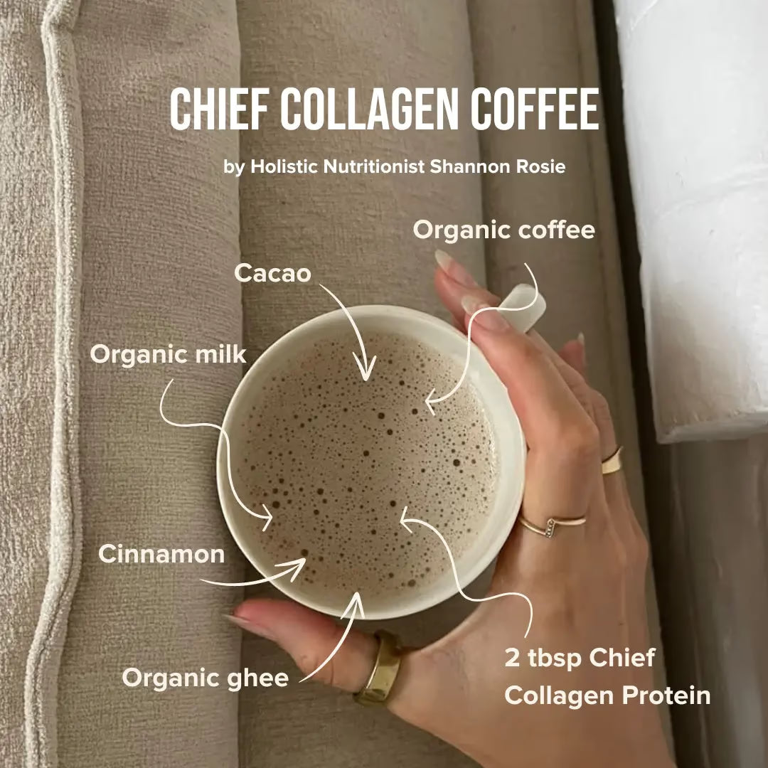 A hand holds a mug of frothy coffee on a beige couch. The coffee contains JING Organics Chief Collagen Protein Unflavoured 450g, organic coffee, cacao, organic milk, cinnamon, and organic ghee—all labeled with arrows pointing to the mug.